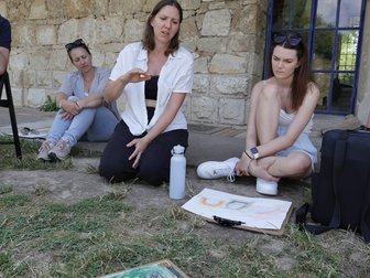 Künstlerin erklärt Kunstwerk im Freien in Wien, zwei Frauen hören zu