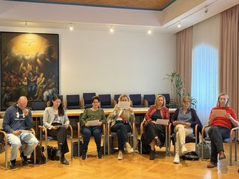 Teilnehmerinnen und Teilnehmer eines Seminars in einem Konferenzraum in Österreich mit Gemälde an der Wand.